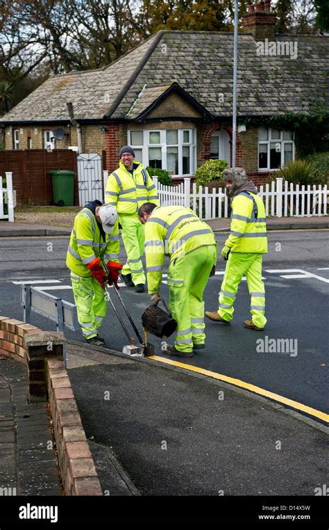 Highway Maintenance Workers Laying Down Double Yellow Lines Stock Photo