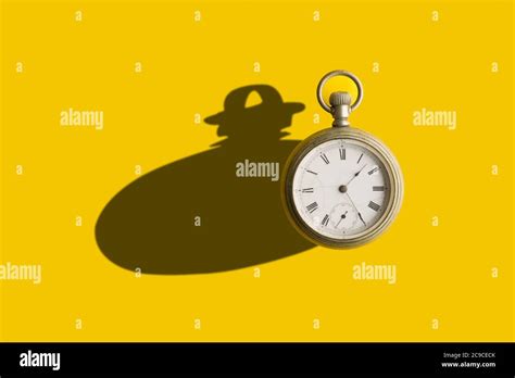 Old Pocket Clock With A Bold Shadow In A Yellow Background Stock Photo