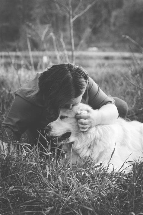 A Woman Is Hugging Her Dog In The Grass