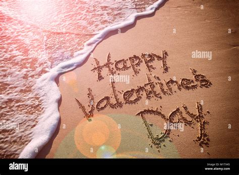 Happy Valentines Day Message Handwritten On Smooth Sand Beach Stock