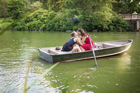 Lesbian Couple Kissing While Sitting In Boat Amidst Lake Photograph By
