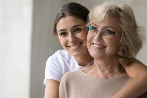 Smiling Mature Mother And Adult Daughter Look In Distance Dreaming