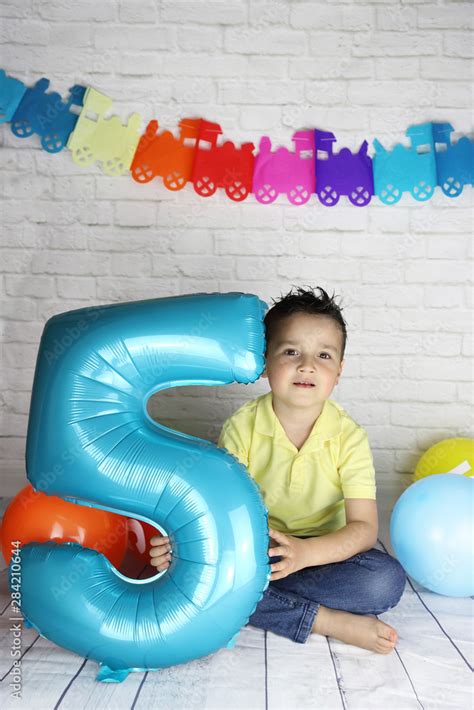 Niño De 5 Años En Su Fiesta De Cumpleaños Con Globos Y Guirnaldas Foto