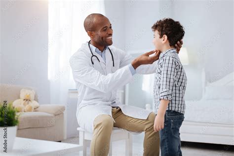 Regular Examination Cheerful Gay Male Doctor Looking At Boy Who Standing In Profile And