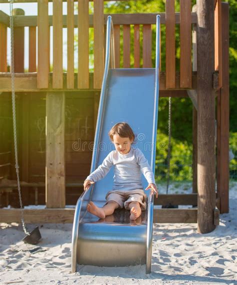 Little Girl Playing On Slide At The Playground Stock Photo Image Of