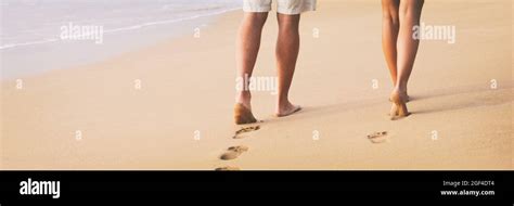 beach couple walking barefoot on sand at sunset walk honeymoon travel banner woman and man