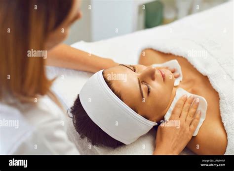 Cosmetologist Or Masseur Wiping Relaxing Womans Neck After Facial Massage In Beauty Salon Stock