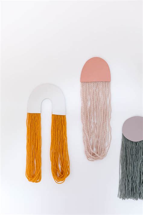 Tie yarn around one spoke where the dowels meet in the center, then wrap it over and around the spoke next. DIY Yarn Art Wall Hangings | Fall For DIY