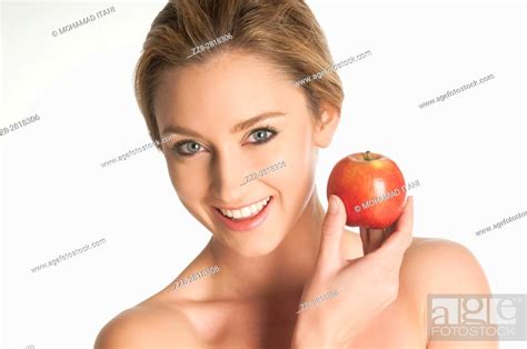 Beautiful Nude Blonde Woman Holding A Red Apple Smiling Against A White