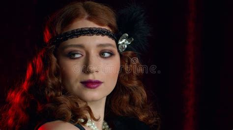 old fashioned woman dressed in style of flappers posing on dark background roaring twenties