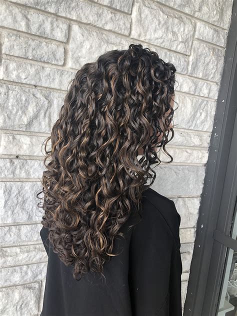 partial honey high lights on dark brown curly hair for a subtle look curlyhair curlygirlme