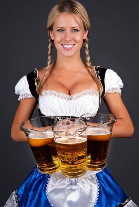 German Barmaid In Braids Wearing Dirndl And Holding Pitchers Of Beer