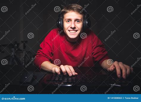 Happy Young Gamer Looks At The Computer Monitor And Smiles Video Game