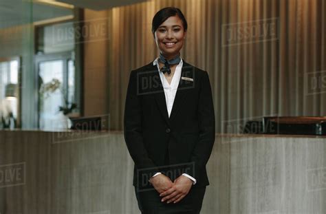 happy smiling female receptionist in hotel beautiful concierge in uniform waiting for welcoming