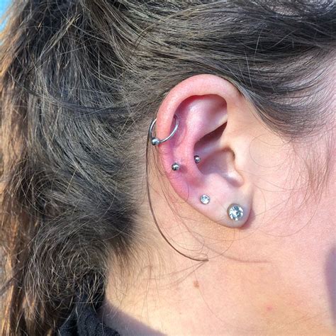 A Close Up Of A Person With Ear Piercings On Their Ears And Behind The Ear