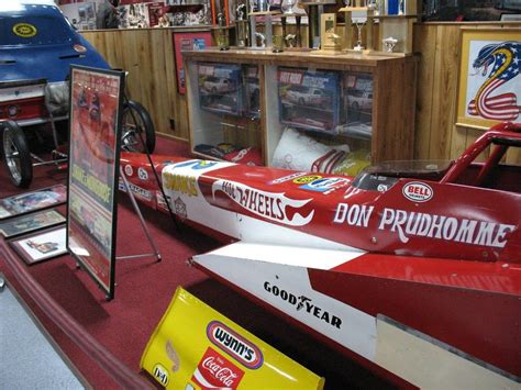 A Red And White Race Car On Display In A Shop