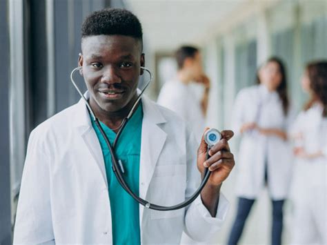 African Black Doctor Man With Stethoscope Standing In The Corridor Of