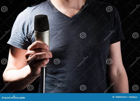 Male Singer On The Stage Holding A Microphone On A Dark Stock Image