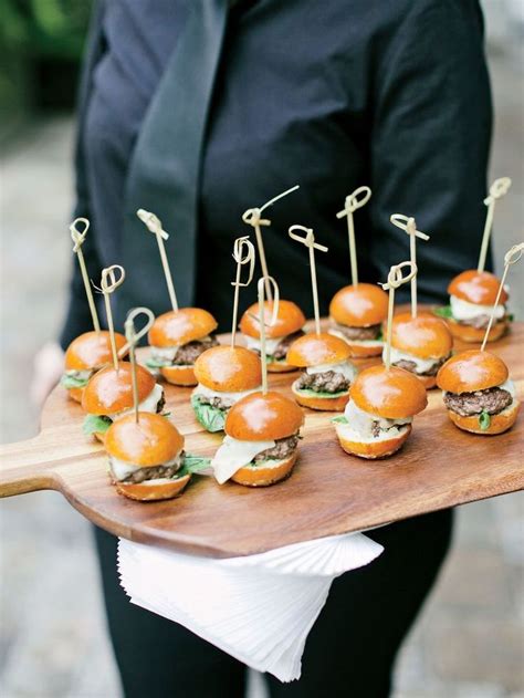 A Tray With Mini Burgers And Toothpicks On It Ready To Be Served