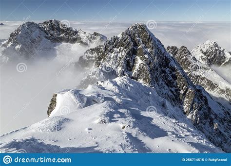 View Of Dramatic Rocky Snowy Mountain Range Peaks With Mist And