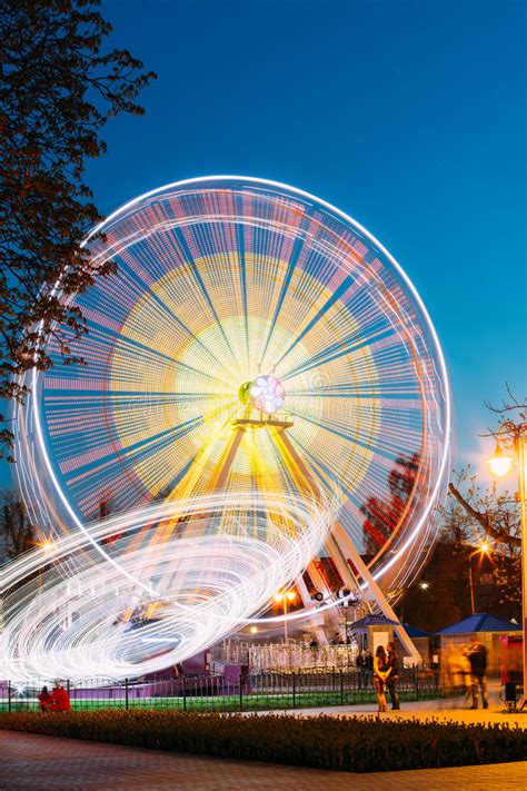 Rotating In Motion Effect Illuminated Attraction Ferris Wheel On Summer