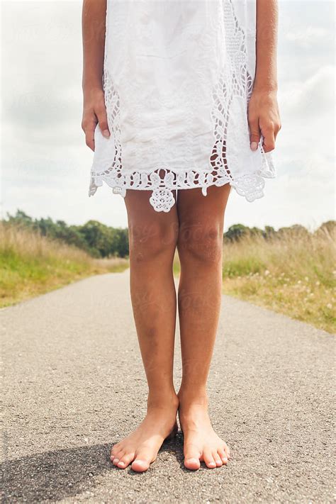 Bare Feet And Legs Of A Little Girl In A White Dress Stocksy United