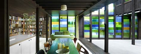 Cottage With Colored Glass Walls And Pre Existing Trees