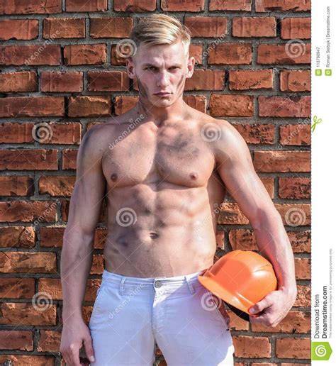 Construtor Com Torso Muscular E Capacete Parede De Tijolo No Fundo