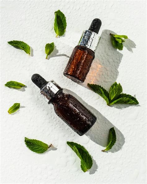 A Bottle With Essential Oil And Mint On A White Background Essential