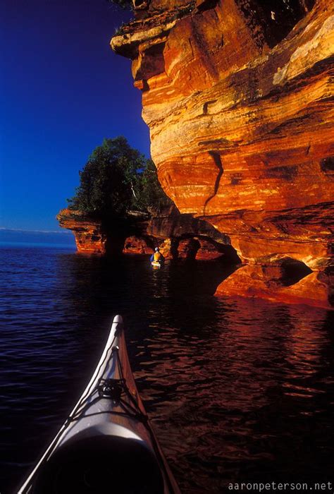 Sea Kayakers Explore The Sandstone Cliffs And Caves On Devils Island In