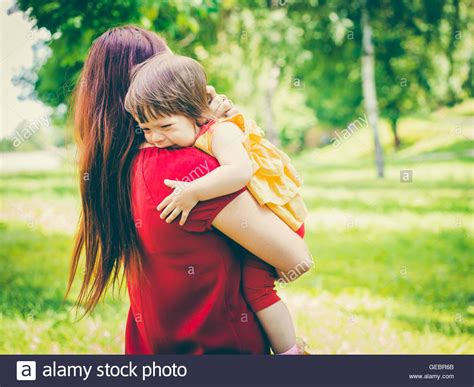 Mother Holding Her Crying Cute Baby Girl Stock Photo