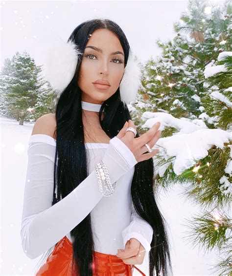 A Woman With Long Black Hair Wearing A White Top And Red Skirt In The Snow