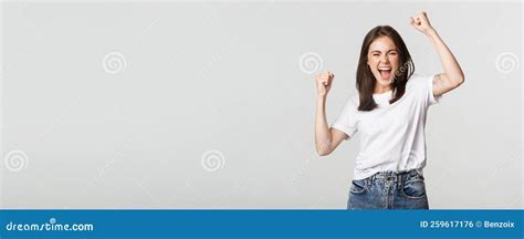 Cheerful Attractive Brunette Girl Fist Pump And Smiling With Rejoice