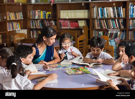 Indian School Kids And Teacher Teaching Students Book Study In Library