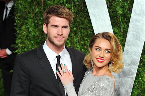 are miley cyrus and liam hemsworth married pictures show the singer in a white dress cutting a