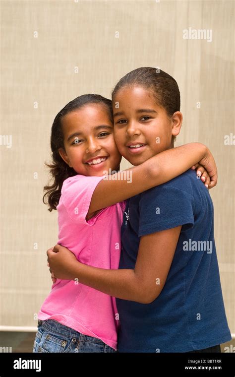 Portrait Of Two African American Caucasian Sisters Hugging Mr © Stock