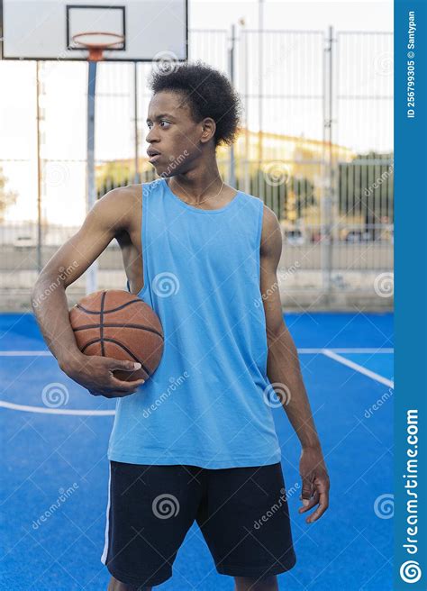Portrait Of A Serious Basketball Player Holding Ball Looking To A Side