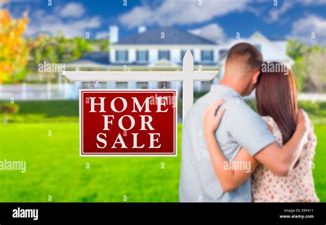 For Sale Real Estate Sign And Affectionate Military Couple Looking At