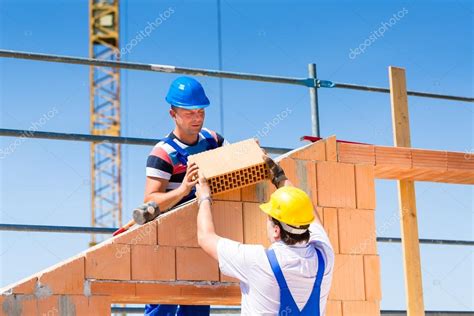 Bricklayer Or Builders On Construction Site Working Stock Photo By