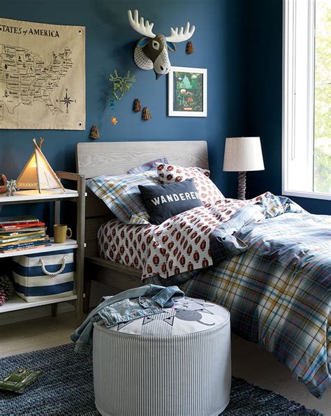 The elegance and stability of the navy blue is here enhanced by herringbone patterned wooden floors and herringbone gray rug both adding dynamic to an otherwise still interior, neutral palettes are used on textiles while rose copper and golden accents are being inserted on the light fixtures to increase the sumptuousness of the interior. Grey and Navy Boys Bedroom | Crate and Barrel