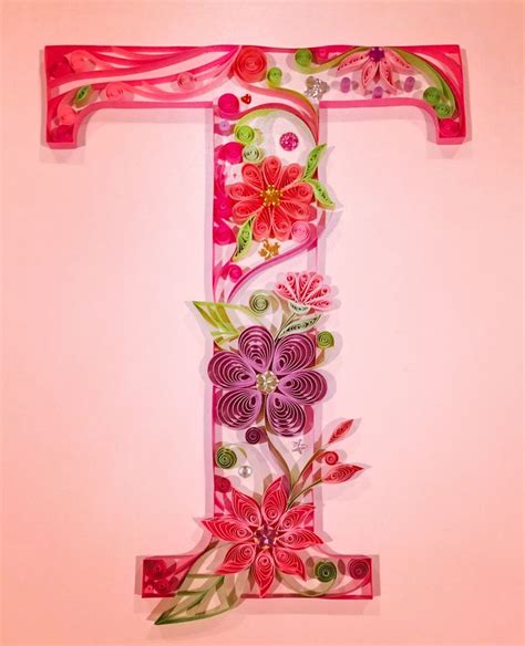 The Letter T Is Decorated With Flowers And Leaves