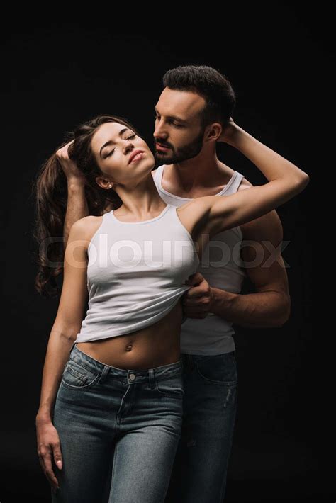 Passionate Man Undressing Girl In White Singlet Isolated On Black Stock Image Colourbox