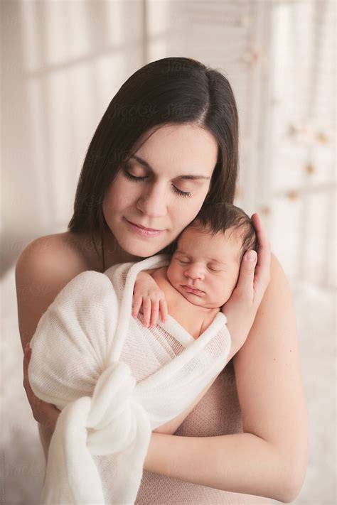 Beautiful Mother Holding Her Newborn Baby Tight By Stocksy