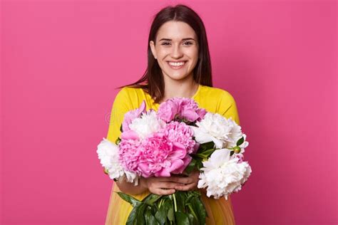 Indoor Shot Of Nice Young Woman Holding Beautiful Fresh Blossoming