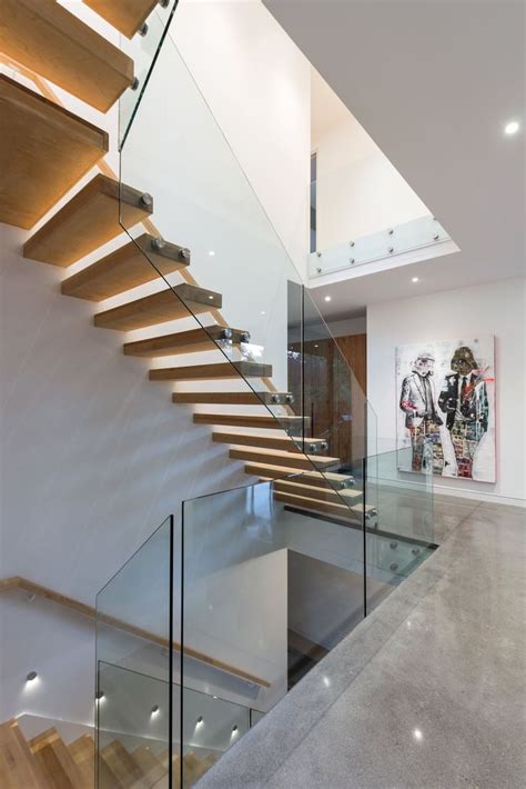 A Staircase With Glass Railing And Wooden Handrails In A Modern Style