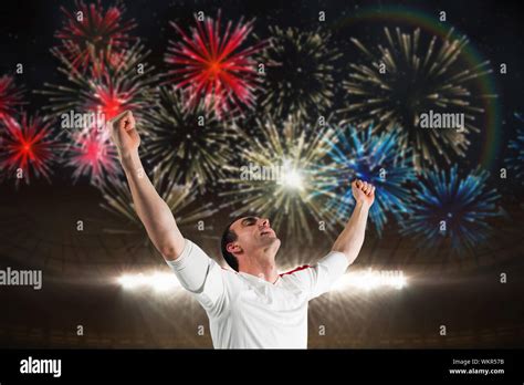 Excited Football Fan Cheering Against Fireworks Exploding Over Football