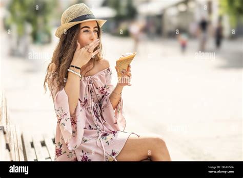 A Beautiful Young Lady Is Licking Her Fingers From Melted Ice Cream On