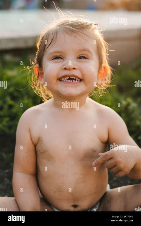 Portrait Of Adorable Baby Girl Playing In The Garden Getting Dirty