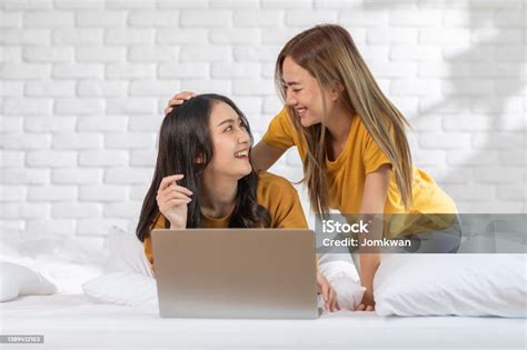 Pasangan Atau Teman Lesbian Muda Asia Yang Cantik Menggunakan Laptop Komputer Bersamasama