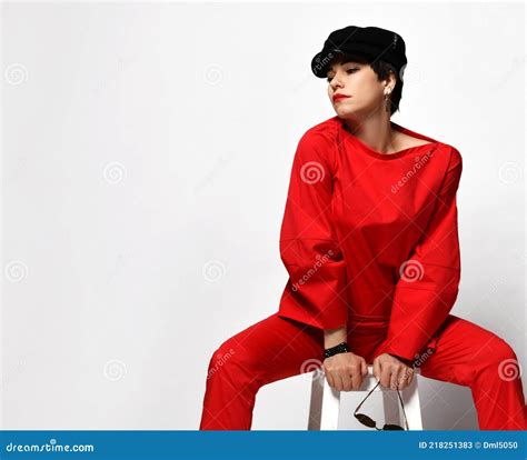Adult Pretty Sensual Short Haired Brunette Woman In Stylish Casual Red Pantsuit And Black Cap